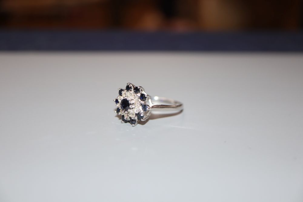 A modern 18ct white gold, sapphire and diamond cluster ring, size S, gross 4.7 grams.